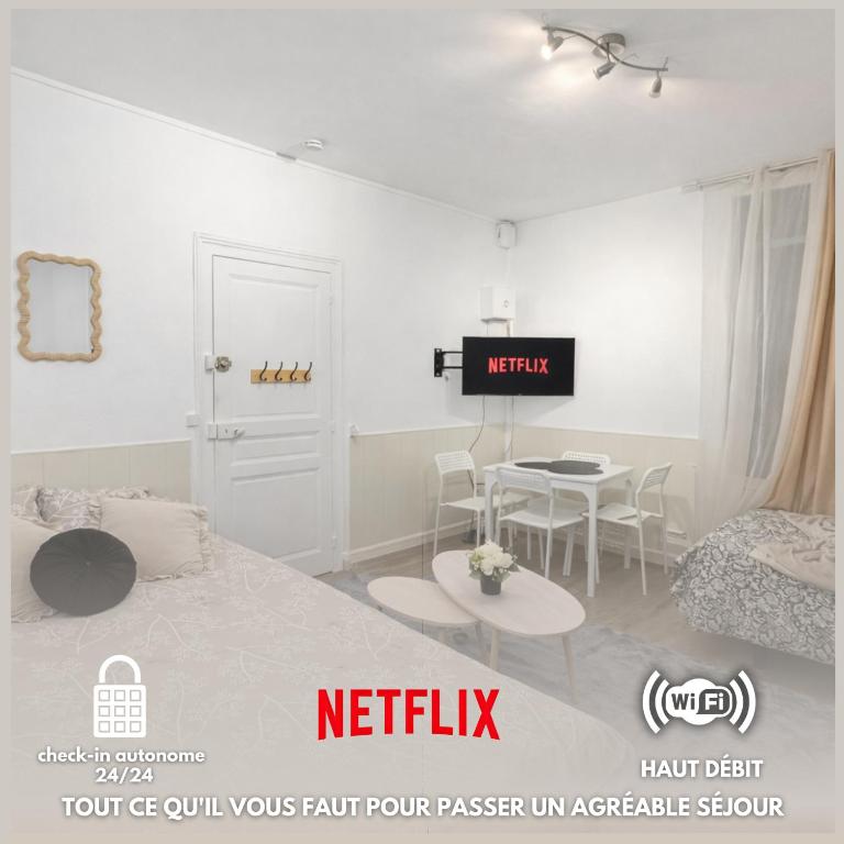 a white room with a bed and a table at Le Signature Studio in Dreux