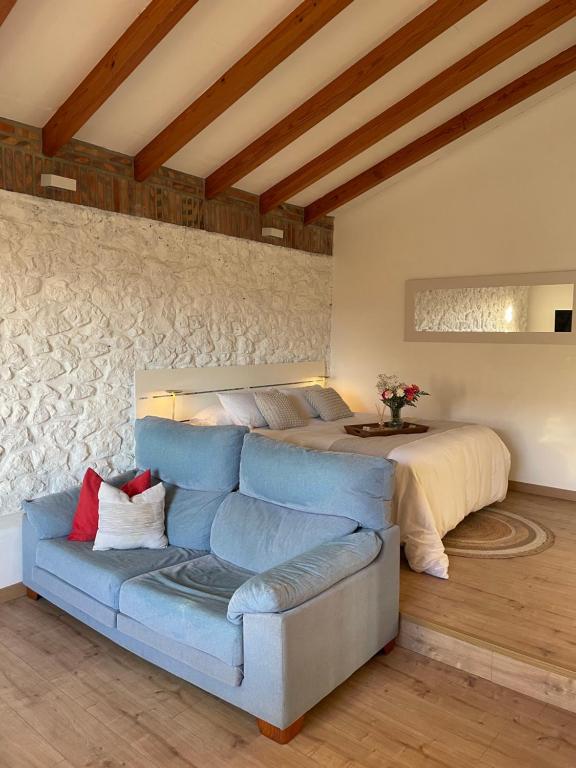 a bedroom with a blue couch and a bed at Bahía de Pedreña 2 in Pedreña