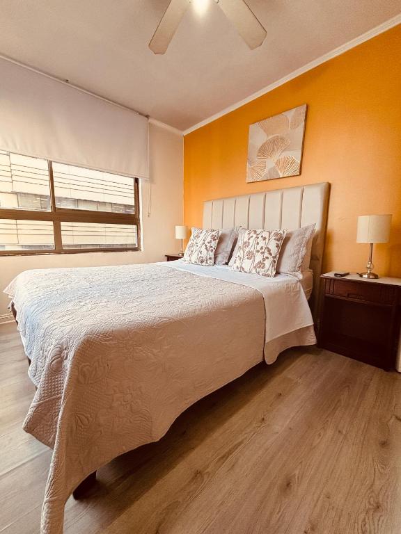 a bedroom with a large bed with orange walls at Deptos En Centro De Santiago in Santiago