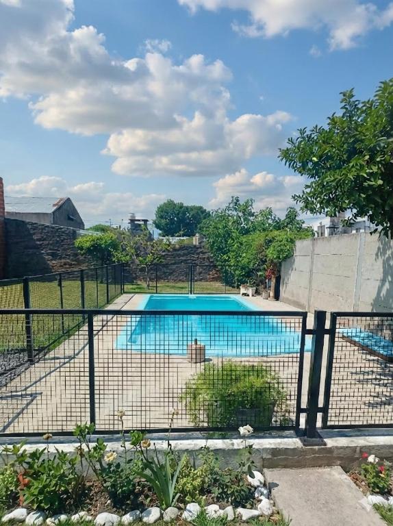 a fence with a swimming pool in a yard at Quinta Estrella in San Pedro