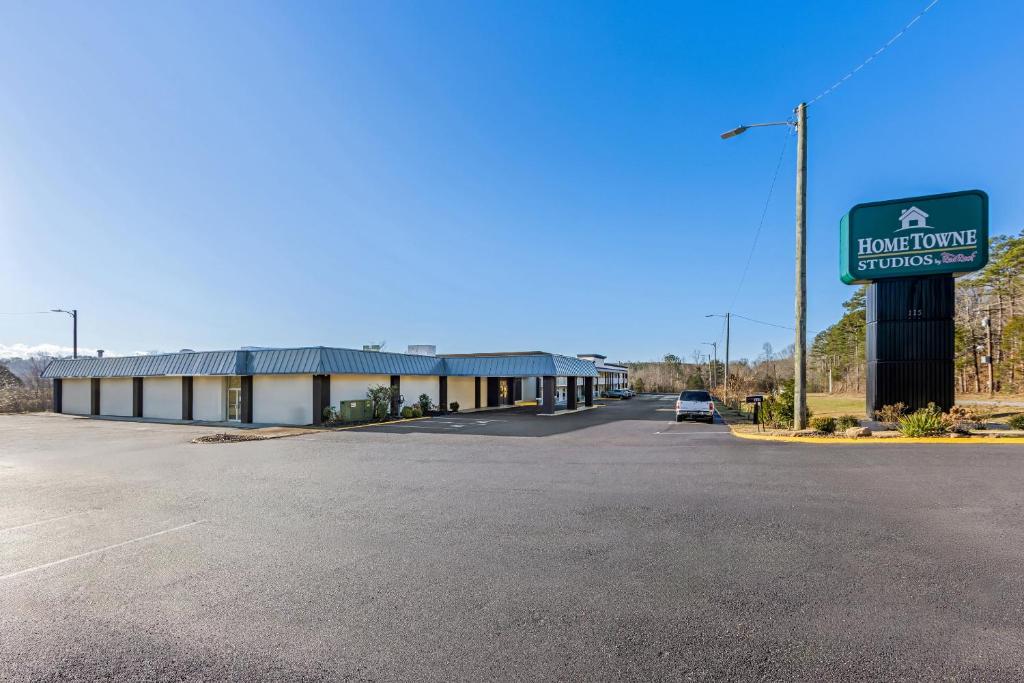 a building with a sign in front of a parking lot at HomeTowne Studios by Red Roof Athens, TN in Athens