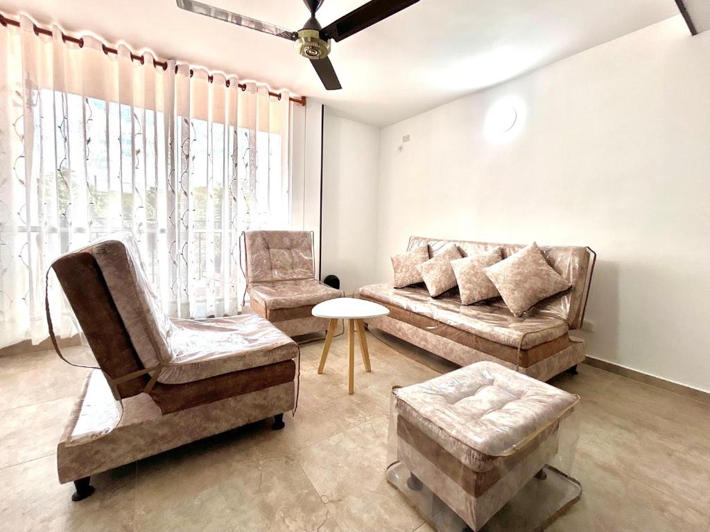 a living room with two chairs and a couch at Las Palmas Paraíso Ricaurte in Ricaurte