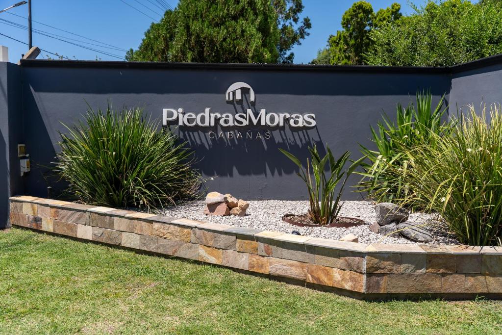 a sign for a professional landscaping company with plants at Piedras Moras cabañas in Almafuerte