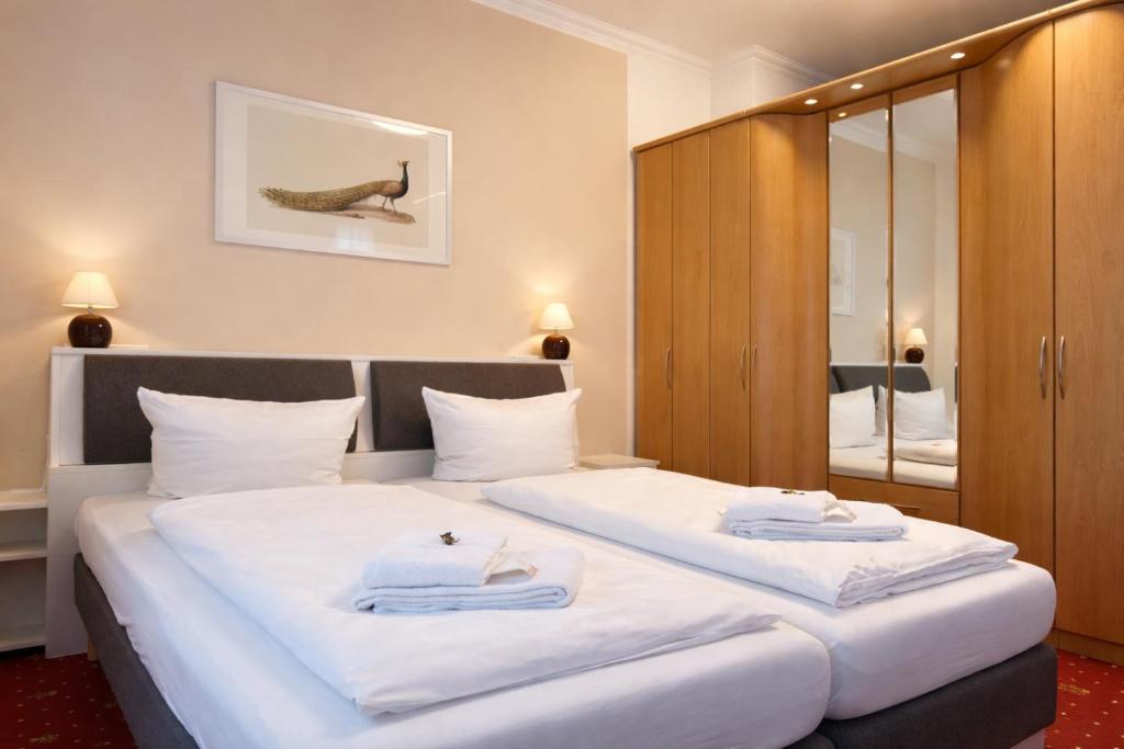 a bedroom with a large bed with towels on it at FRAME by Tendo Stay - Comfort Housing in Falkensee