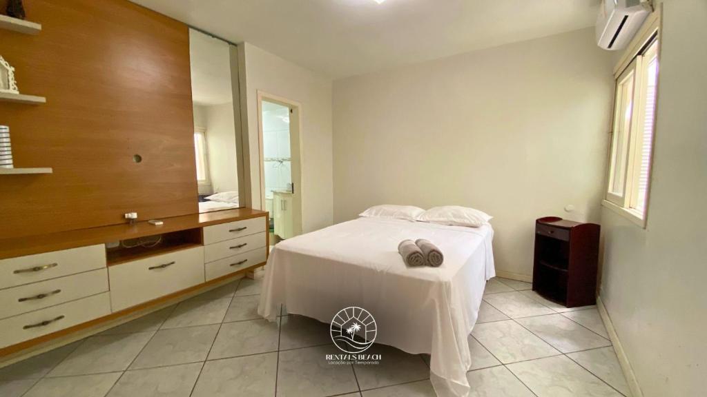 a bedroom with a bed with a dresser and a mirror at Casa centro de Torres – 500 mts do mar in Torres