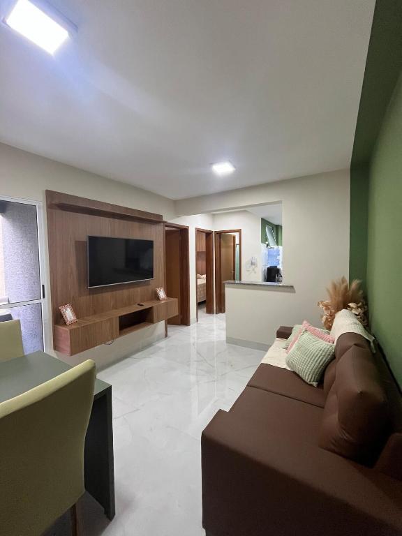 a living room with a couch and a flat screen tv at Impera House Terreo Ar nos 2 quartos in Imperatriz