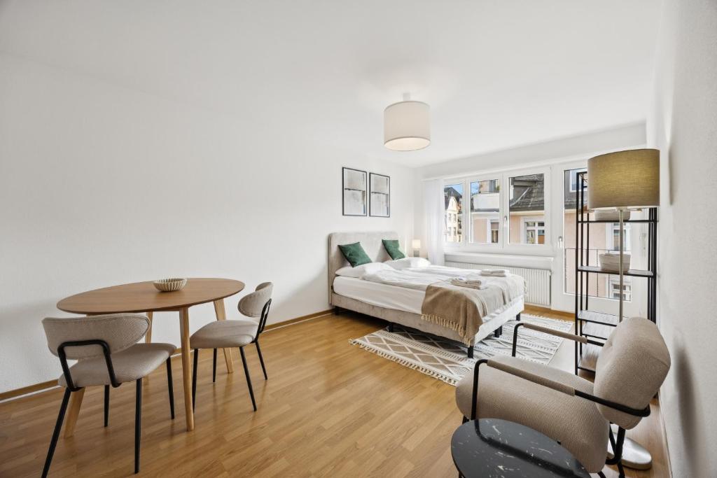a living room with a bed and a table and chairs at Very centrally located studio - Crown 15 in Zurich