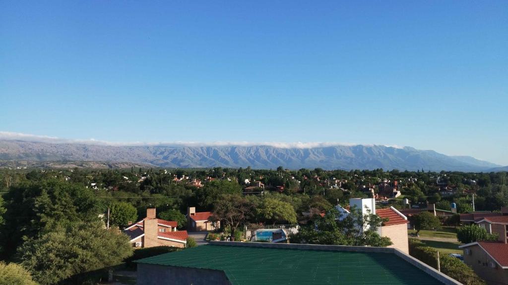 a city with a green roof and mountains in the background at Complejo Alto Paraiso in Villa Cura Brochero