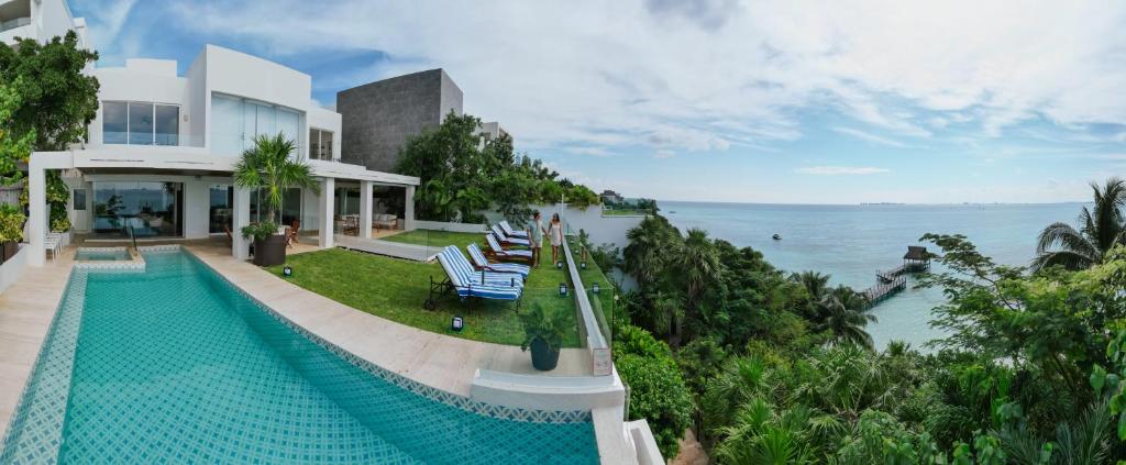 a house with a swimming pool next to the ocean at Villa Chan Kah in Isla Mujeres