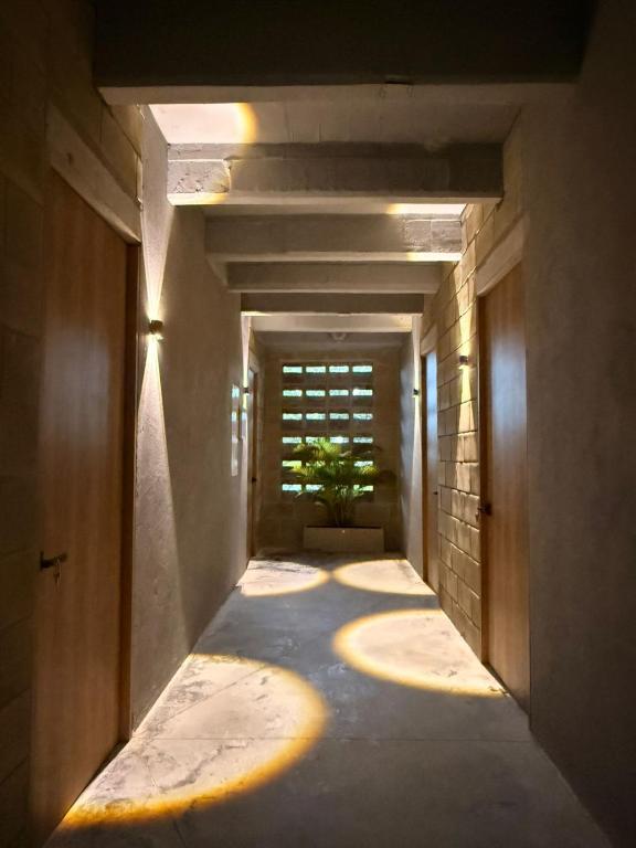 a hallway with a plant in the middle of a building at Aira Hotel in Coveñas