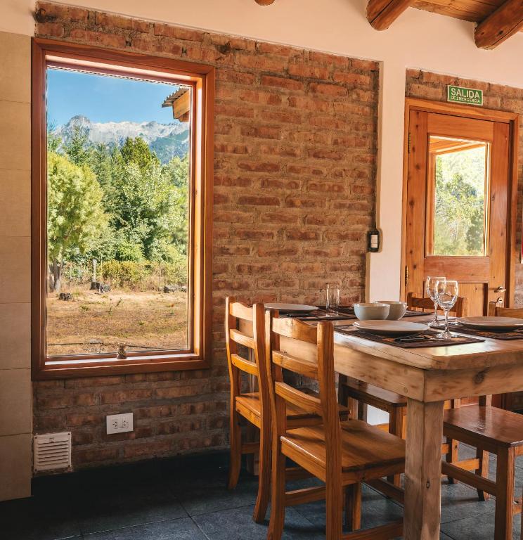 a dining room with a table and chairs and a window at Cabure in Epuyén
