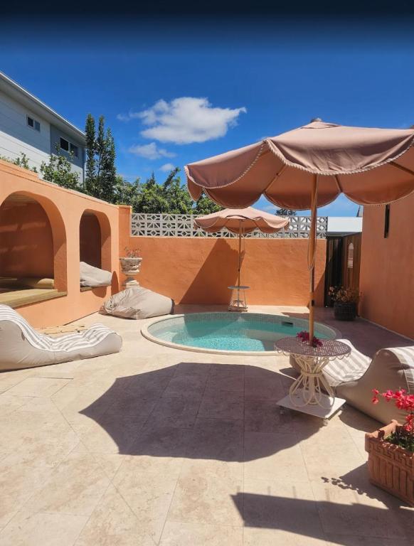 a patio with an umbrella and a swimming pool at Pacific Sun Bargara in Bargara