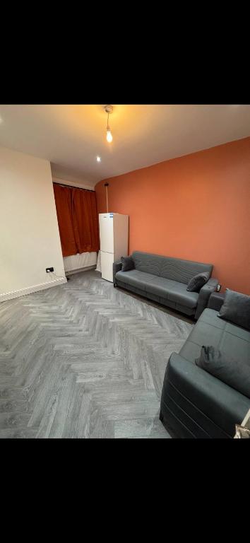 a living room with two couches and a refrigerator at Mayford Shared House in Manchester