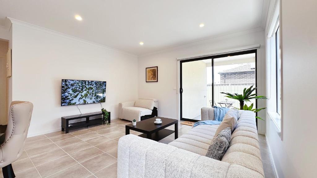 a living room with a couch and a tv at Lyra 2026 Home by GoodLive in Beveridge