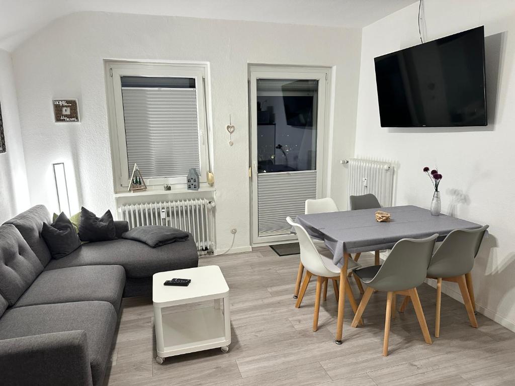 a living room with a couch and a table with chairs at Fewo Andresen Hahnenklee in Hahnenklee-Bockswiese