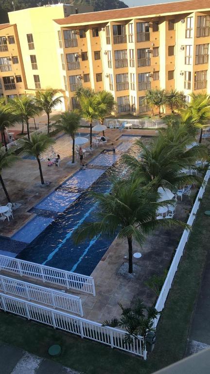 an overhead view of a pool with palm trees and buildings at Loft reserva do Sahy- condado in Mangaratiba