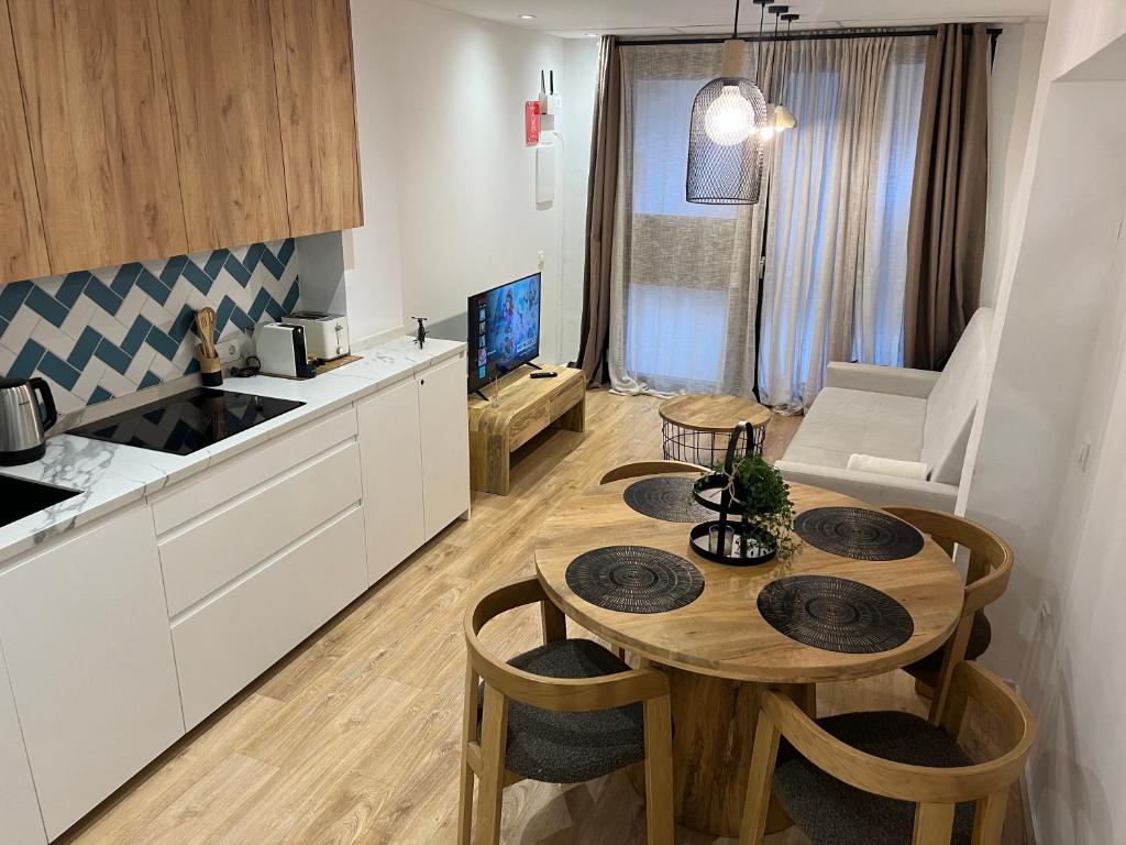 a kitchen and dining room with a table in a kitchen at Apartamento acogedor frente a Plaza del Cedro in Valencia