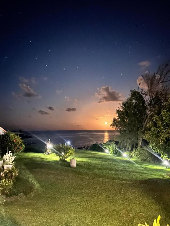 a yard with a view of the ocean at night at Caribbean Lotus in Le François