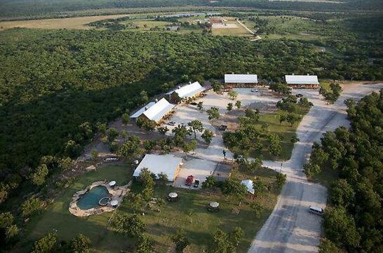 an aerial view of a farm with buildings and trees at Wildcatter Ranch and Resort in Graham