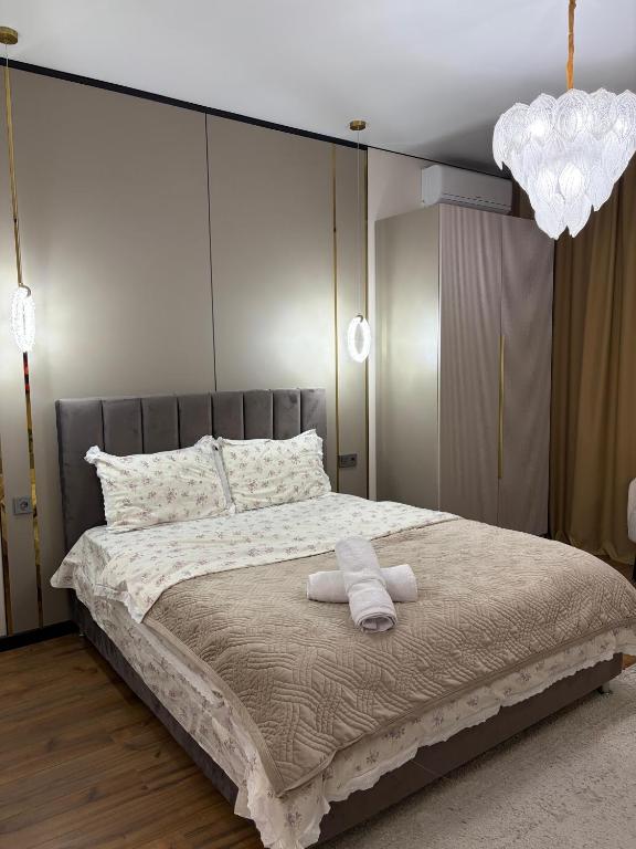 a bedroom with a large bed with two towels on it at The Grand CentraL Studio & Люкс Студия в Центре Города Алматы in Almaty