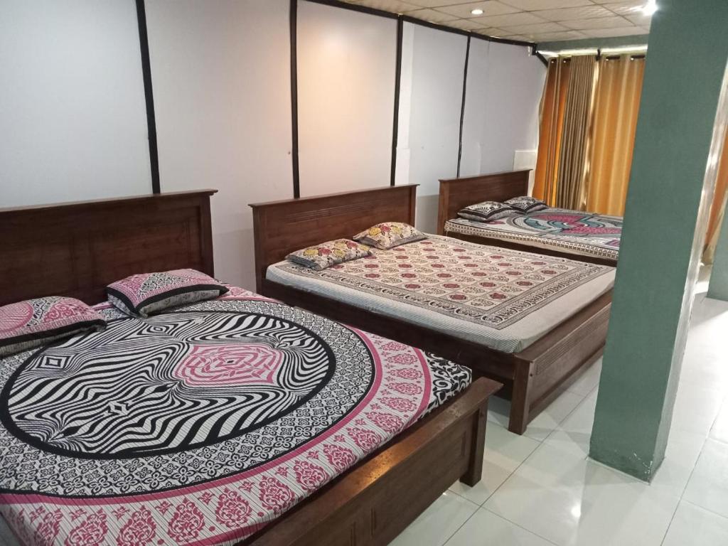a room with three beds in a room at Beehive Inn Bambalapitiya in Colombo