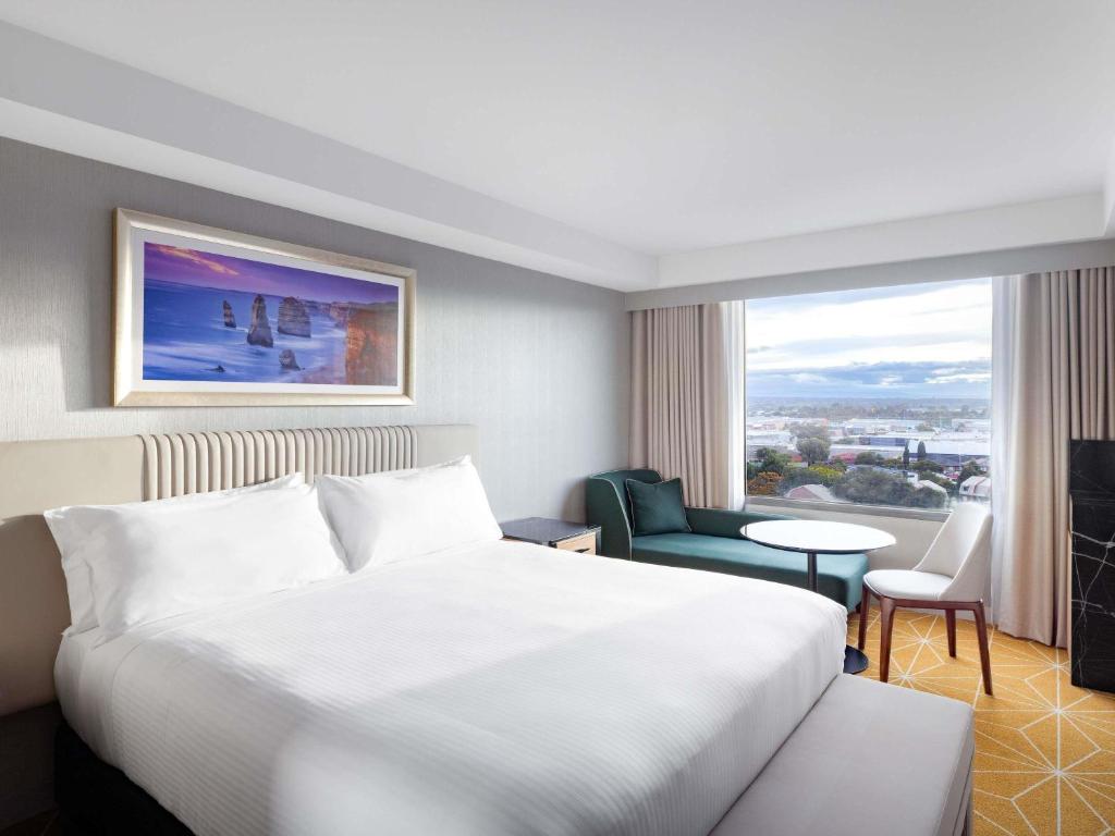 a hotel room with a bed and a large window at Mantra Melbourne Airport in Melbourne
