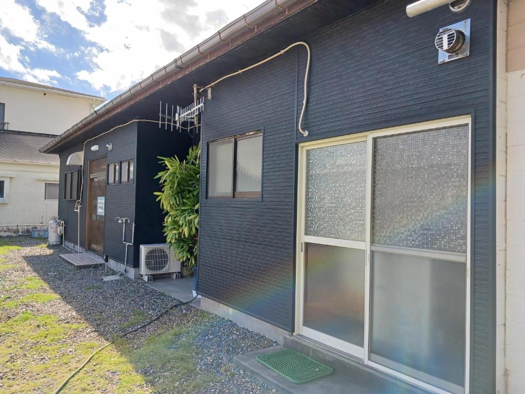 a black house with a rainbow painted on the side of it at GuestHouseさがら丸 in Niijimamura