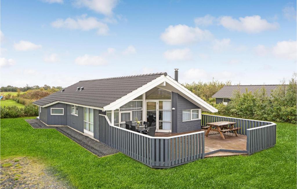 a tiny house with a deck and a patio at Amazing Home In Tarm With Sauna in Tarm