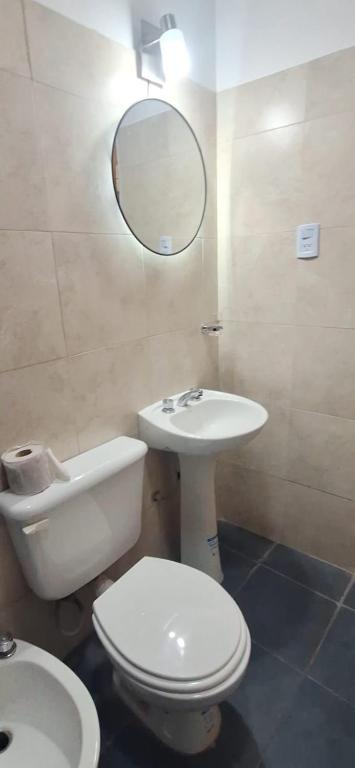 a bathroom with a toilet and a sink and a mirror at La Guarida 3 in Concepción
