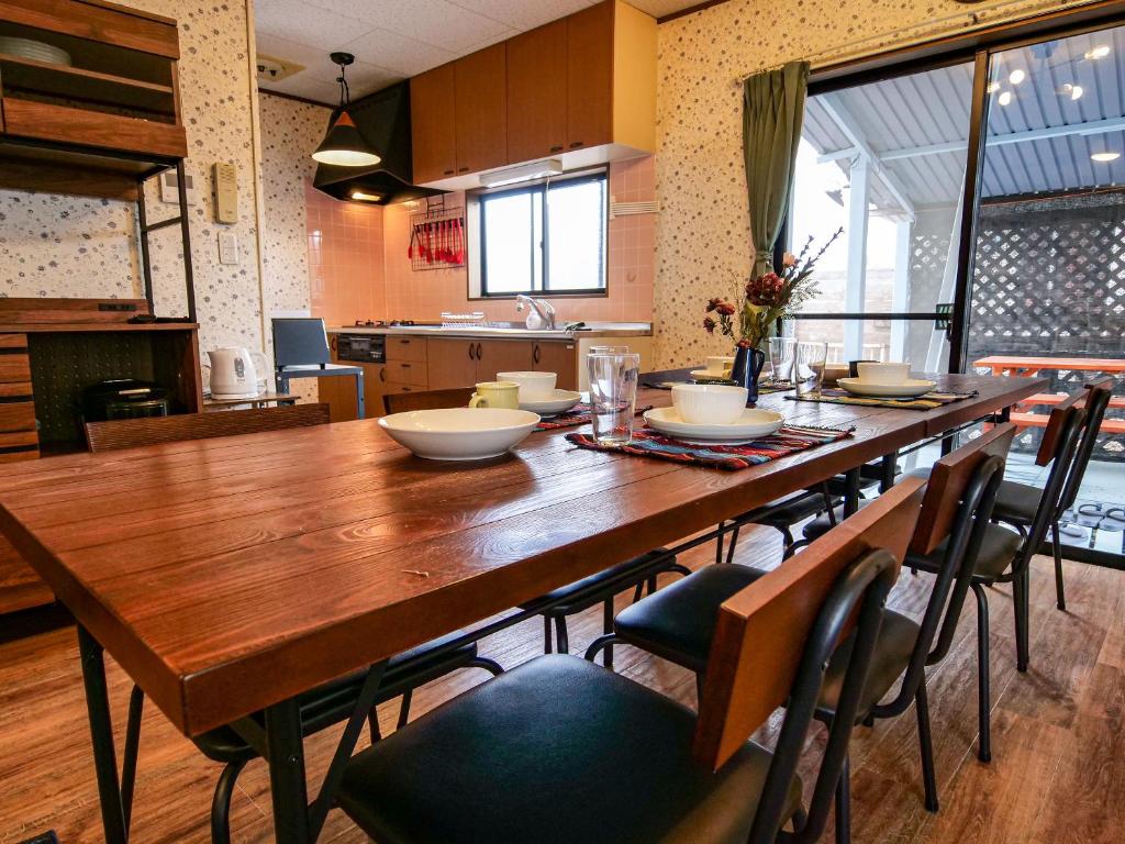a large wooden table with chairs in a kitchen at Villa228KASAMA in Kasama