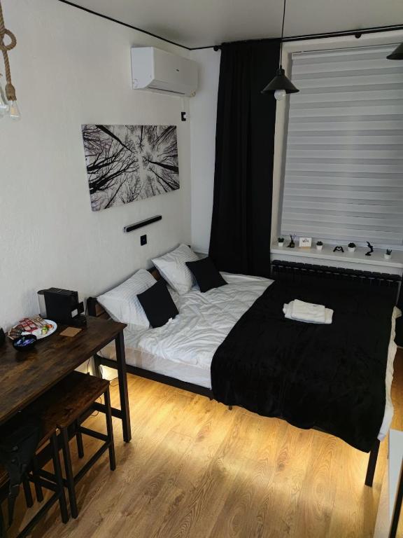a bedroom with a bed and a desk and a window at Smart Loft Studio Center Walking street in Chişinău
