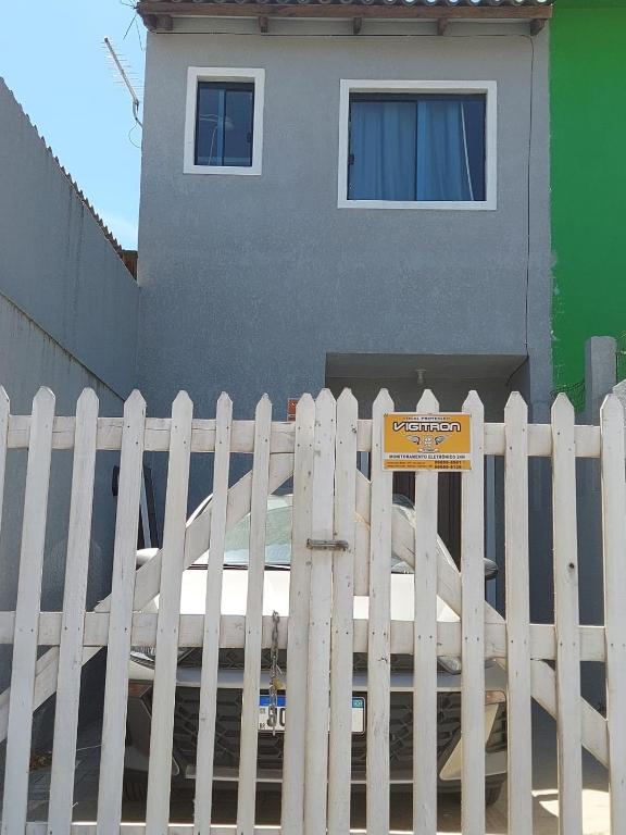 a white fence with a sign in front of a house at Sobrado próximo ao mar em Salinas in Cidreira