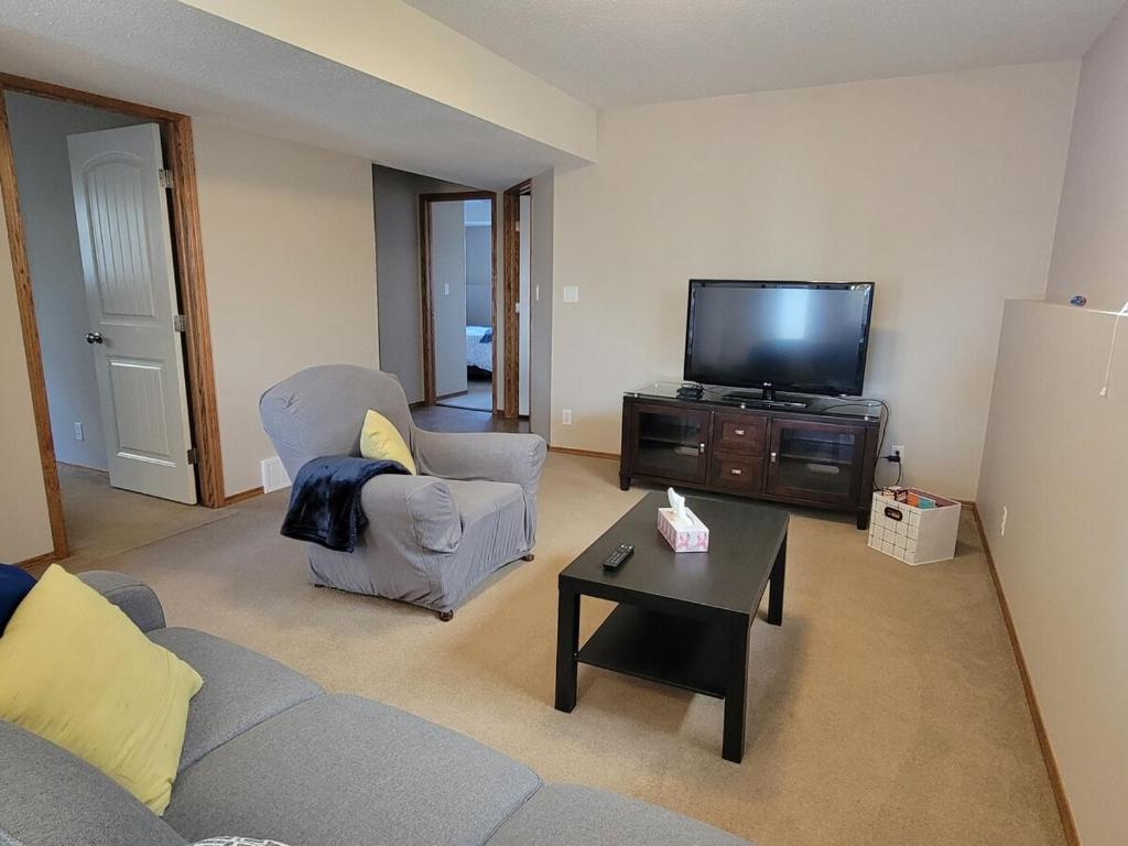 a living room with a couch and a tv at Quaint Lonsdale Suite in Red Deer