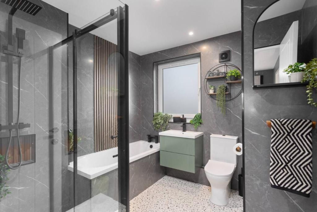 a bathroom with a toilet and a tub and a sink at Paradykes House in Loanhead