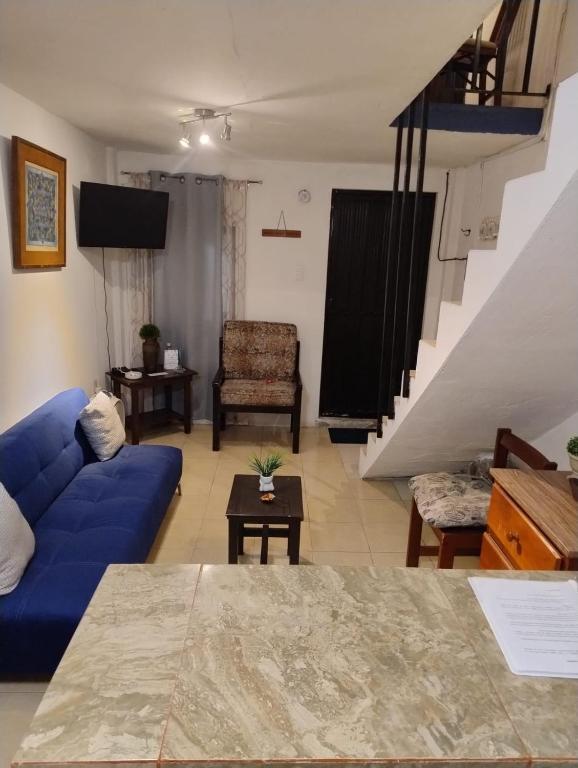 a living room with a blue couch and a table at Bungalow Turrent, a 5 minutos de Playa Mocambo in Veracruz