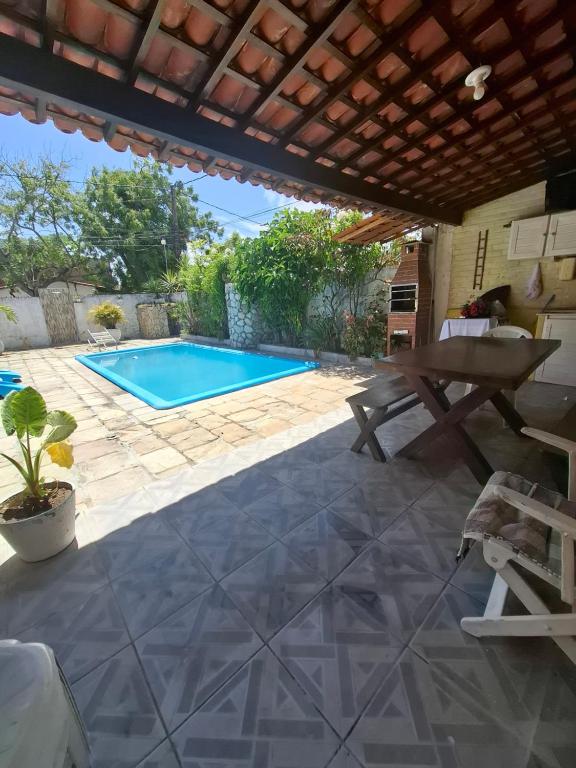a patio with a swimming pool and a table at Kitnetilha in Itamaracá