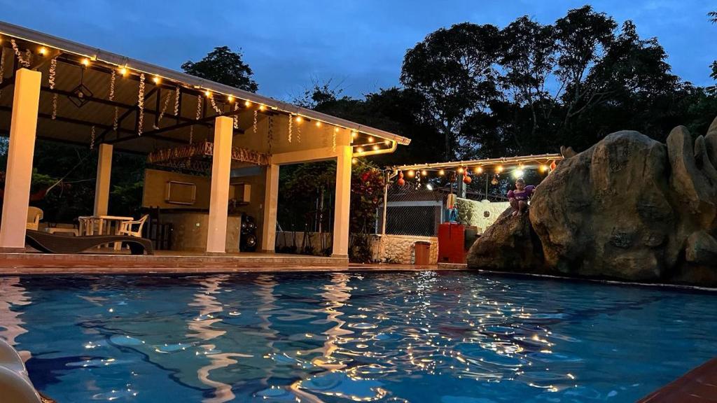a swimming pool in front of a house with lights at Finca Turística VILLA NELLA in Acacías
