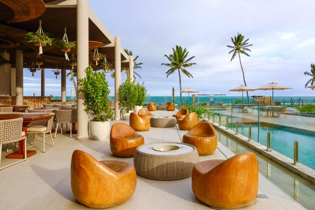 a hotel patio with chairs and a pool at Resort beira mar in Porto De Galinhas