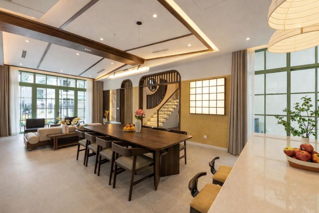a dining room and living room with a table and chairs at Hana Village Garden Tropical Bãi Khem in Phú Quốc