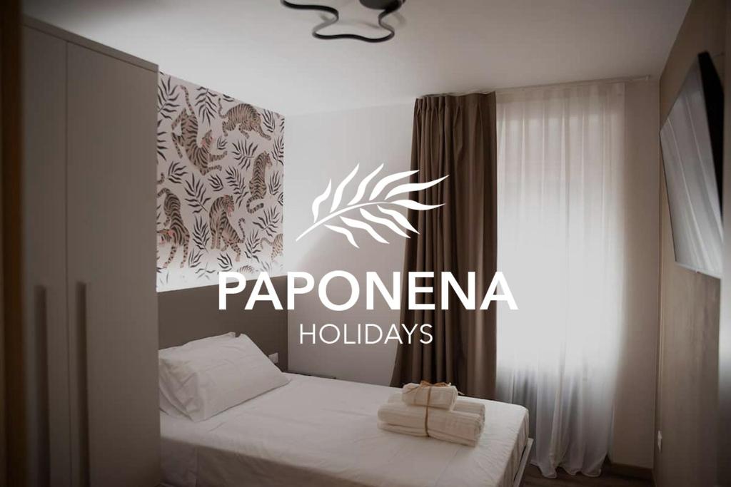 a bedroom with a bed with a sign on it at Paponena Holidays in Riva del Garda