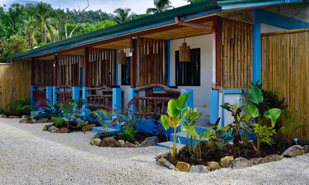 a house with a bunch of plants in front of it at Azuls Tourist Inn in San Vicente