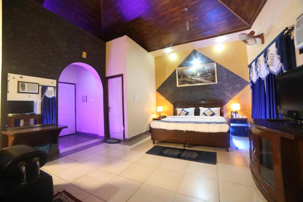 a bedroom with a bed in a room with purple walls at Kangs Nirvana Resorts and Spa in Hoshiārpur