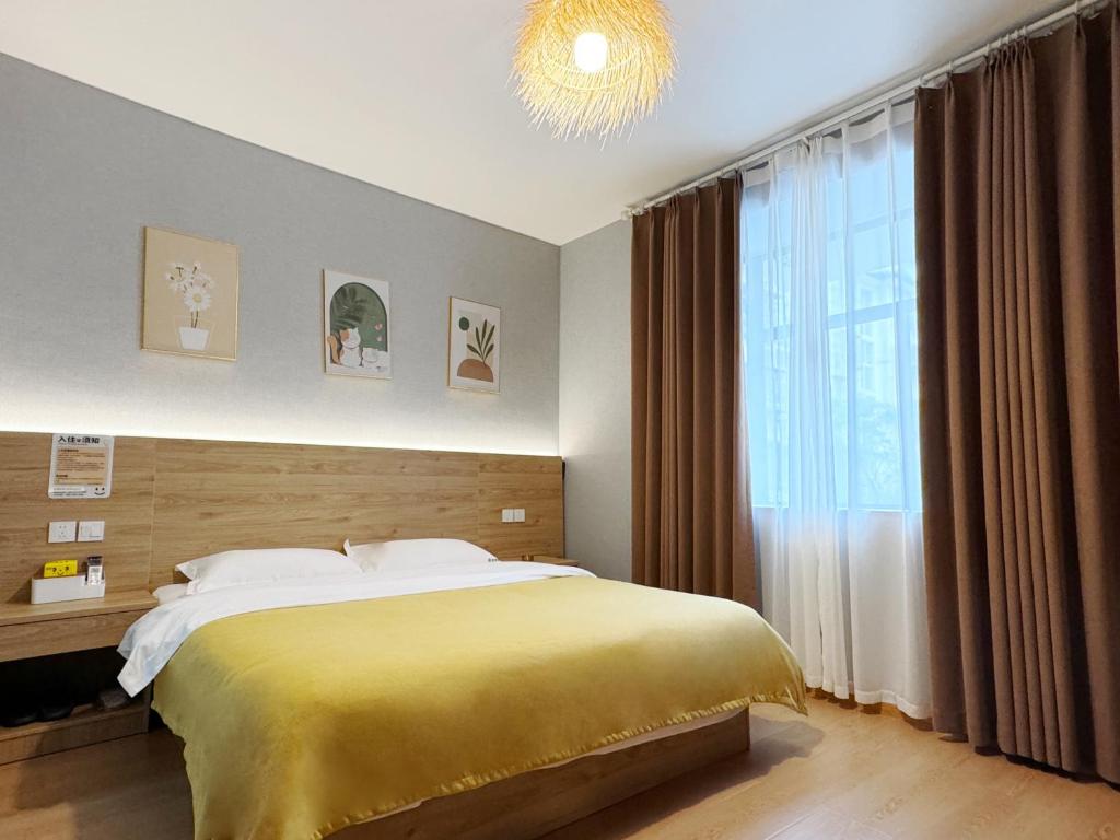 a bedroom with a bed and a large window at 恩宜客栈 in Dujiangyan