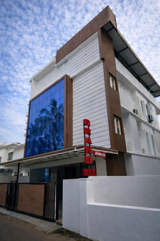 a building with a red sign in front of it at Grand UNX in Kannur