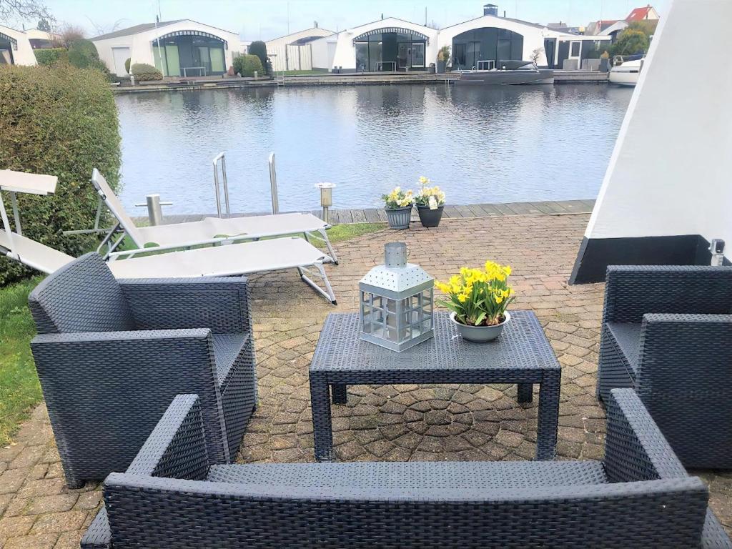 a patio with wicker chairs and a table with flowers at Aquaronde 119 in Lemmer