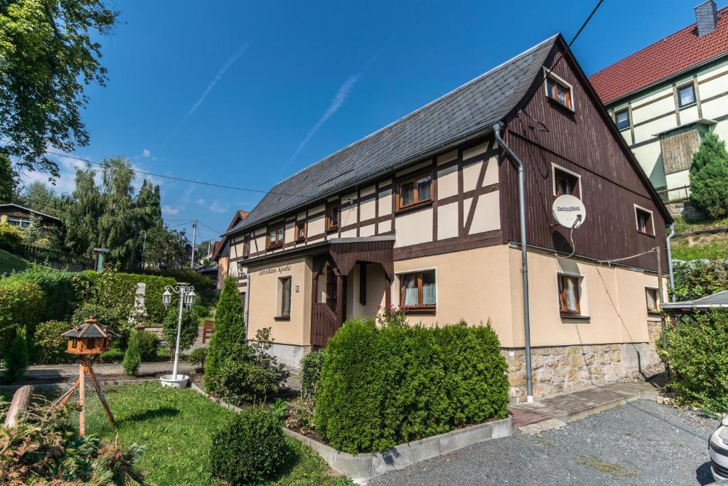 a brown and white building with a black roof at Ferienhaus Rosalie Ruhiges Ferienhaus mit Garten direkt am Malerweg in Altendorf