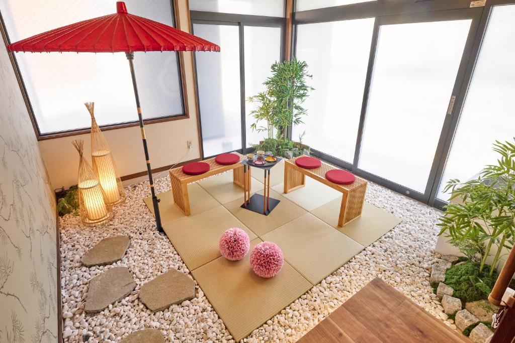 a living room with a red umbrella and a table at R STAY Nagoya Atsuta in Nagoya