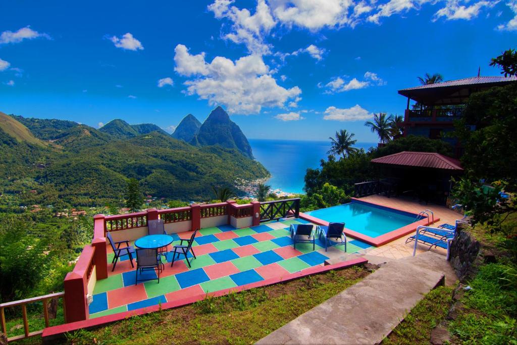 a pool with a view of the ocean and mountains at Samfi Gardens in Soufrière