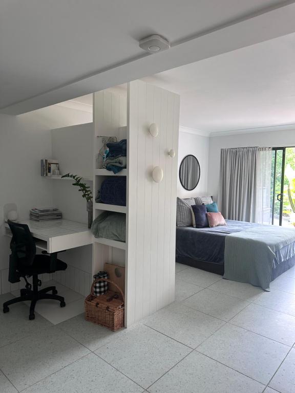a bedroom with a bed and a desk and a computer at Mediterranean Studio & Garden View Private Pet Friendly in Brisbane