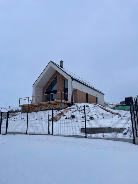 a house behind a fence in the snow at Chalet Aria in Hyby